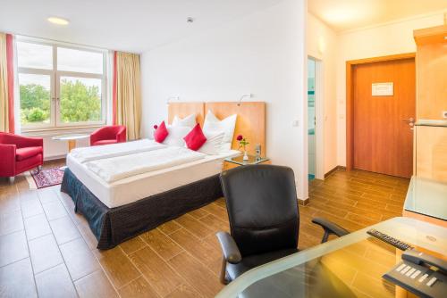 a hotel room with a bed and a desk with a computer at Taba Hotel in Kellinghusen