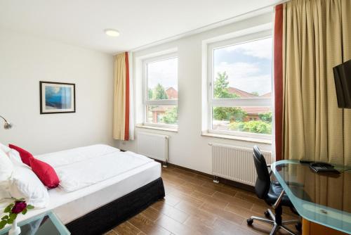 a hotel room with a bed and two windows at Taba Hotel in Kellinghusen