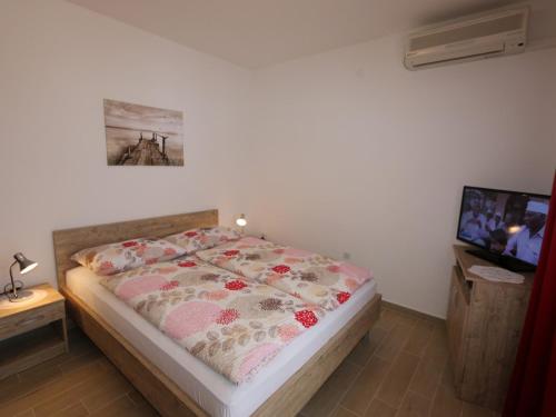 a bedroom with a bed and a tv on a wall at Apartment in Silo/Insel Krk 13439 in Šilo