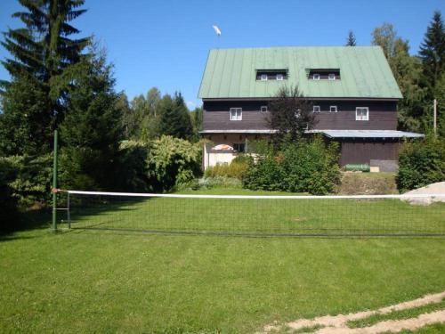 una casa con una red en un patio con en Horsky hotel Sport en Josefuv dul