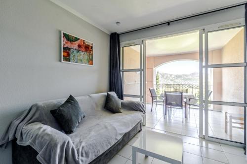 d'un salon avec un canapé et un balcon. dans l'établissement Residence Le Hameau Cap Esterel - maeva Home, à Agay