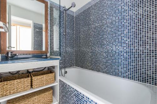 une salle de bain avec une baignoire, un lavabo et un miroir dans l'établissement Residence Le Hameau Cap Esterel - maeva Home, à Agay