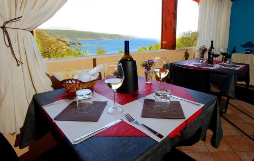 a table with wine glasses and a view of the ocean at Hotel Villa Belfiori in Torre Dei Corsari