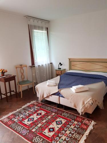 a bedroom with two beds and a rug at Butterfly Guest House in Venice