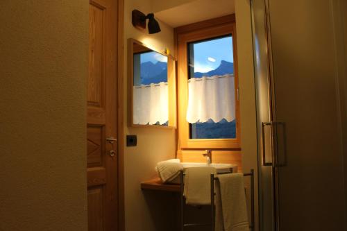 een badkamer met een wastafel en een raam bij Le jardin de Pierre in Nus