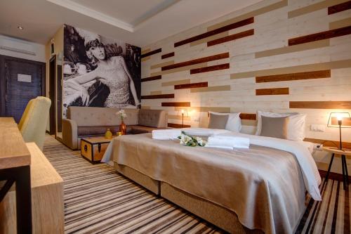 a hotel room with a large bed and a wall at Garni Hotel Zavicaj in Belgrade