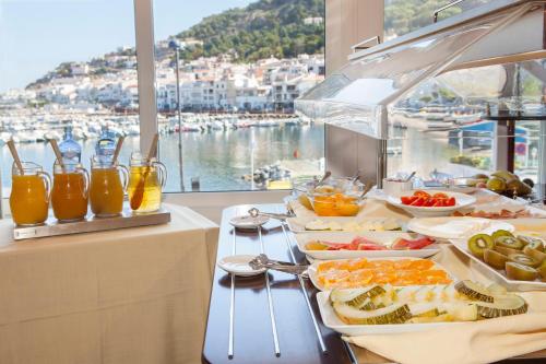a buffet with food and a view of a harbor at Hotel Spa Cap de Creus in Port de la Selva