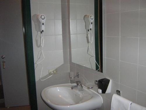 a bathroom with a sink and a phone on the wall at Hostiliae Ciminiera Hotel in Ostiglia