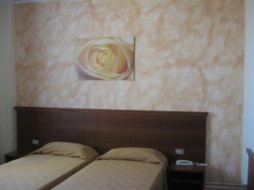 a bedroom with a bed and a painting on the wall at Hostiliae Ciminiera Hotel in Ostiglia