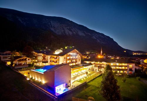 a large building with lights in front of a mountain at Luxury All Inclusive Resort Schwarzbrunn 4 Sterne Superior in Stans