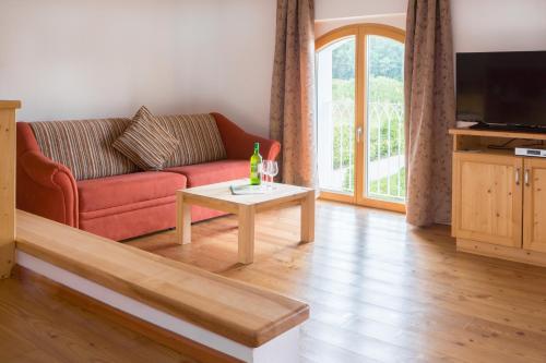 Una sala de estar con un sofá rojo y una mesa de café. en Waldbothgut, en Linz