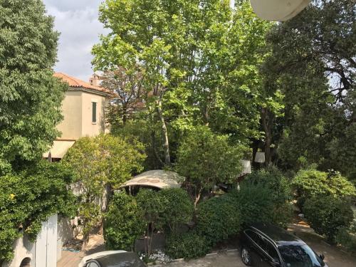 two cars parked in a yard next to a house at Casa Cacao près plage et vélodrome in Marseille