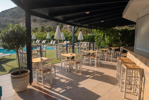 a patio area with tables, chairs and umbrellas at Fragiskos Hotel in Matala