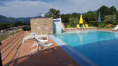 a swimming pool on a deck with two chairs next to it at B&B Podere Montese in Villafranca in Lunigiana