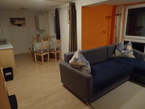 a living room with a blue couch with pillows on it at Haus Bergheim in Sankt Leonhard im Pitztal