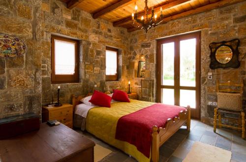 sypialnia z łóżkiem w kamiennej ścianie w obiekcie Athena Villas Olive Grove & Estate w mieście Guwes