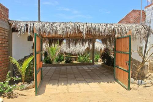 a pavilion with a thatched roof and a patio at Bora Bora Bungalows in Los Órganos