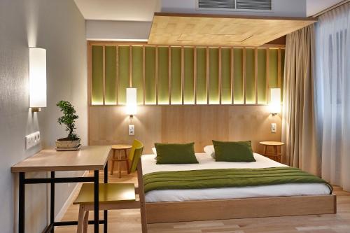 a bedroom with a bed and a table and a desk at Yadoya Hotel in Brussels