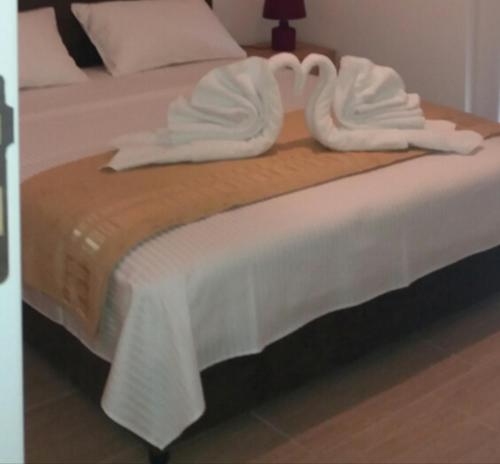 a bed with white towels on top of it at Apartment Vila Mirela in Krimovice