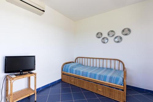 a room with a bed and a tv and a table at Le Casette a Favignana in Favignana