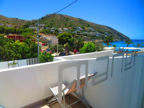 a chair on a balcony with a view of the ocean at HOTEL MAÑET in Moraira