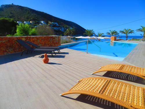 a patio with two chairs and a swimming pool at HOTEL MAÑET in Moraira