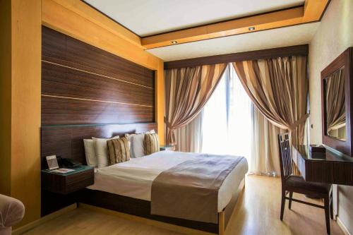 a hotel room with a bed and a window at Imperial Suites Hotel in Beirut