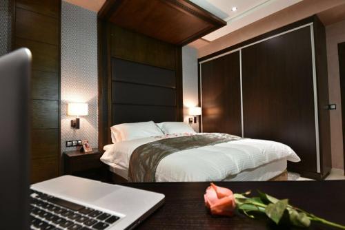 una habitación de hotel con una cama y un ordenador portátil en un escritorio en Bellington Appart Hôtel en Saidia 