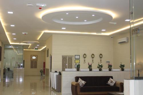 a lobby with a couch in the middle of a building at Sama Sohar Hotel Apartments - سما صحار للشقق الفندقية in Sohar