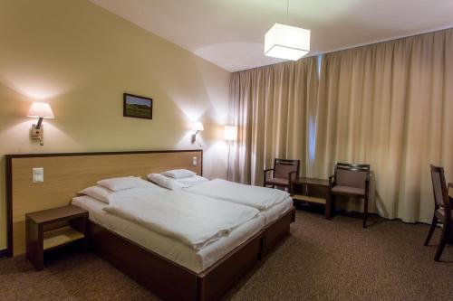 Tempat tidur dalam kamar di Tokajvár Hotel