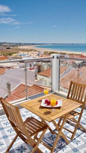 a wooden table with two glasses on a balcony at Topcity Hostel & Suites in Lagos