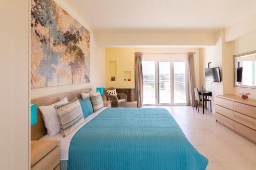 a bedroom with a large bed with a blue blanket at Athena Villas Olive Grove & Estate in Gouves