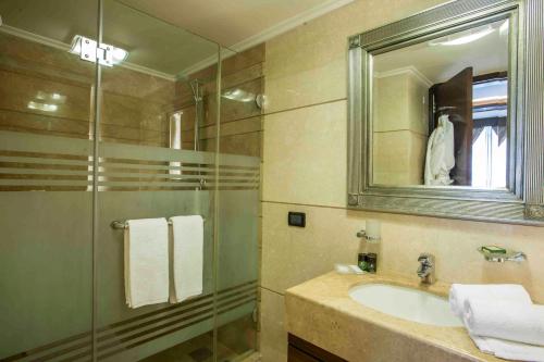 a bathroom with a sink and a glass shower at Imperial Suites Hotel in Beirut