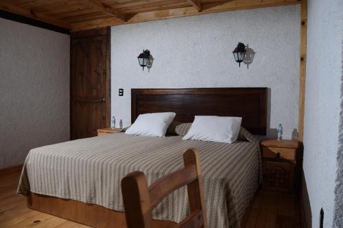 a bedroom with a large bed with a wooden headboard at Campestre DAARLU in Huauchinango
