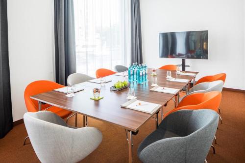 a conference room with a long wooden table and chairs at Capri by Fraser Berlin in Berlin