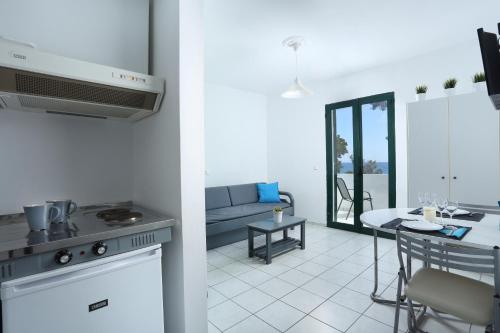 a kitchen and a living room with a stove and a table at The Pines in Skala