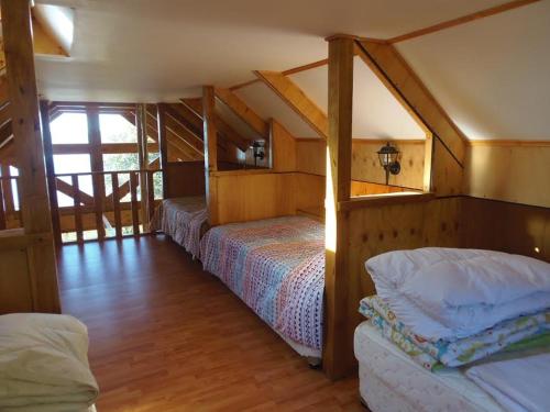 a bedroom with two beds in a attic at Chile Lodge - Lago Huillinco in Notuél