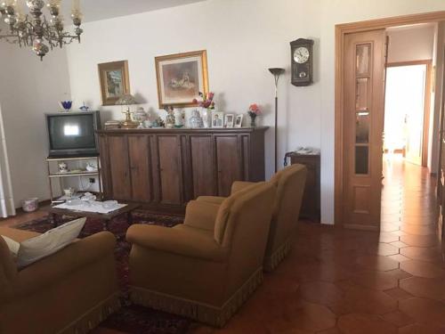 uma sala de estar com duas cadeiras e uma televisão em Villa Marina Big em Laterina