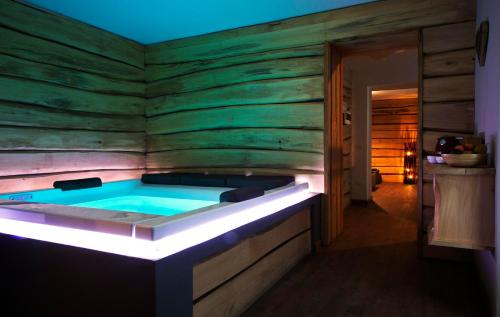 a hot tub in a room with a wooden wall at Residence Cavanis Wellness & Spa in Sappada