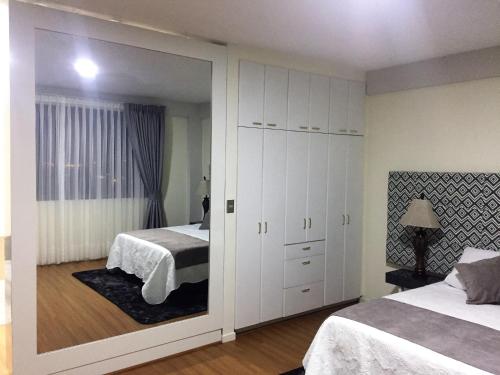 1 dormitorio con 2 camas y un espejo grande en Departamento De Lujo, en Cochabamba