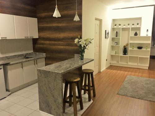 a kitchen with a counter and stools in a room at Departamento De Lujo in Cochabamba