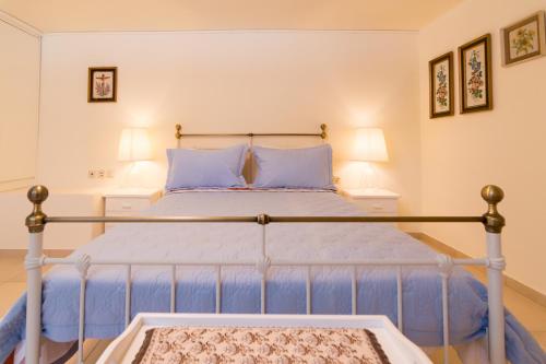 a bedroom with a blue bed with two pillows at Athena Villas Olive Grove & Estate in Gouves