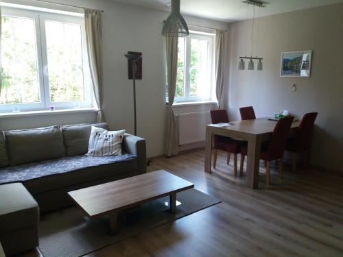 a living room with a couch and a table at Apartmán Špičák Sruby in Špičák