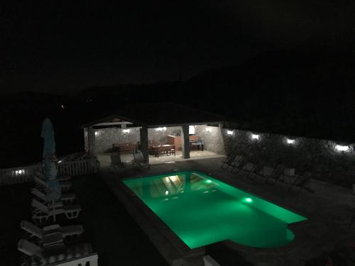 a swimming pool lit up at night with lights at Apartments Vila Lazarevic in Tivat