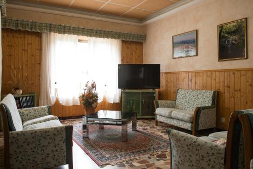 sala de estar con chimenea y TV en La Villa, en Abetone