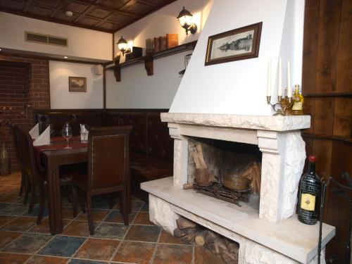 a fireplace in a restaurant with a table with a bottle of wine at Семеен хотел Анна-Кристина in Vidin