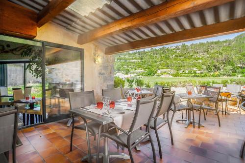 a dining room with tables and chairs on a patio at Logis Hôtel Restaurant des Corbières in Lagrasse