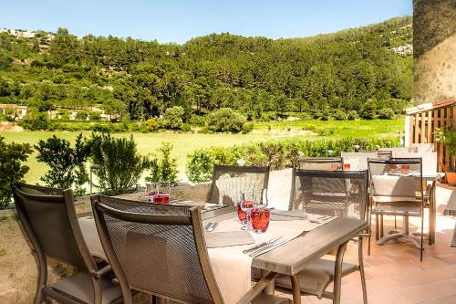 a table and chairs on a patio with a view at Logis Hôtel Restaurant des Corbières in Lagrasse