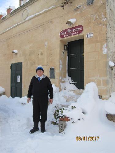 a man standing in the snow in front of a building at Sax Barisano in Matera
