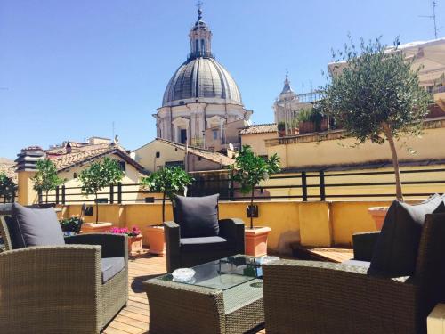 a patio with chairs and a table and a building at Navona Residenza de Charme in Rome